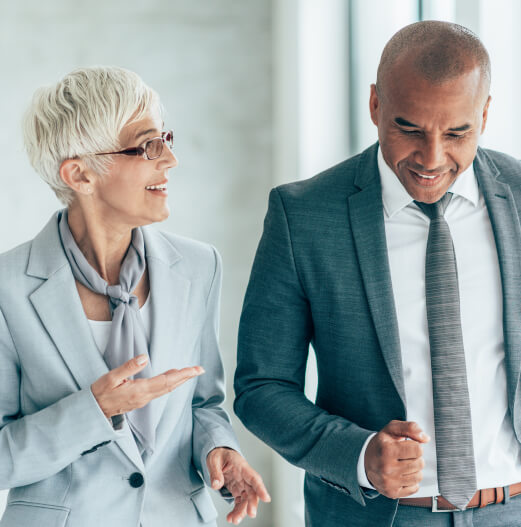Male and female financial advisors in formal business attire engaged in a conversation.