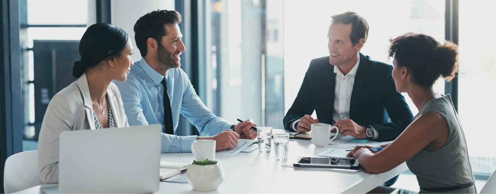 Four coworkers speaking at a table