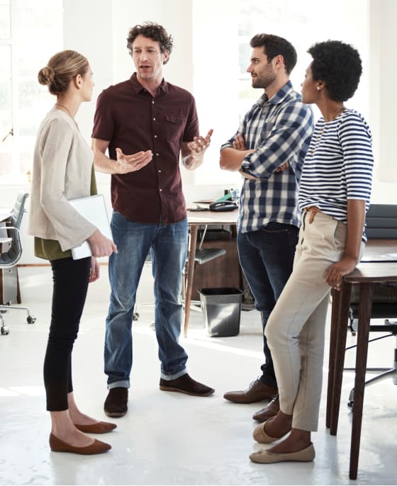 Four coworkers standing and in conversation