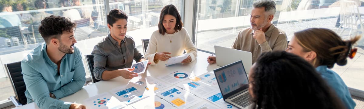 Group of employees collaborate around a large conference table