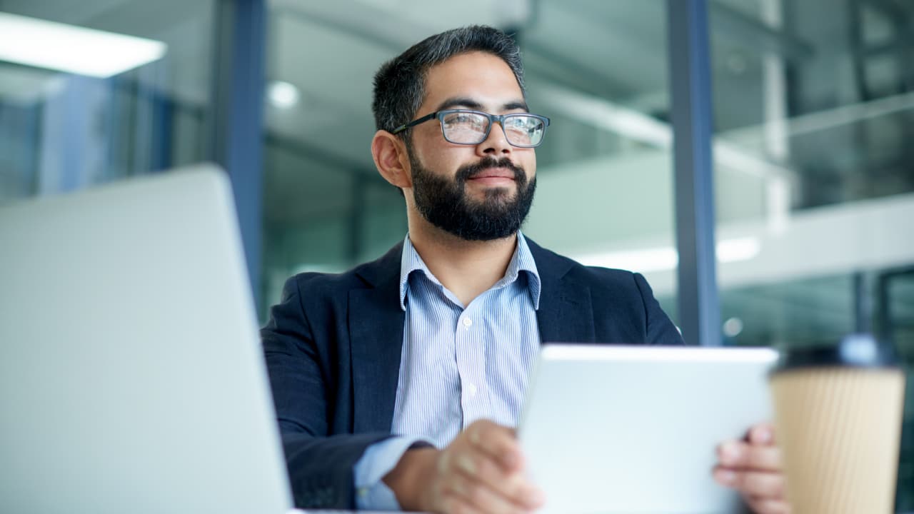 Man reviewing laptop and tablet