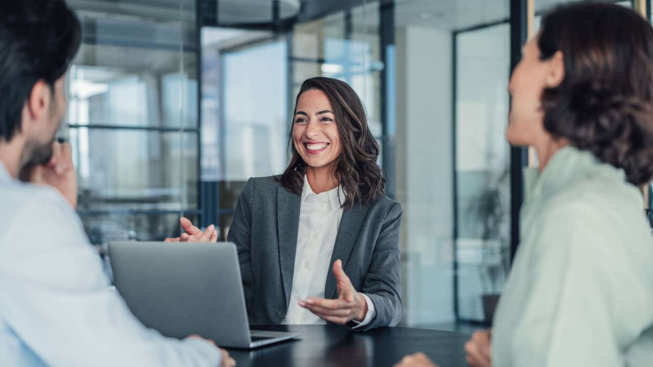 Woman smiling and talking to coworkers