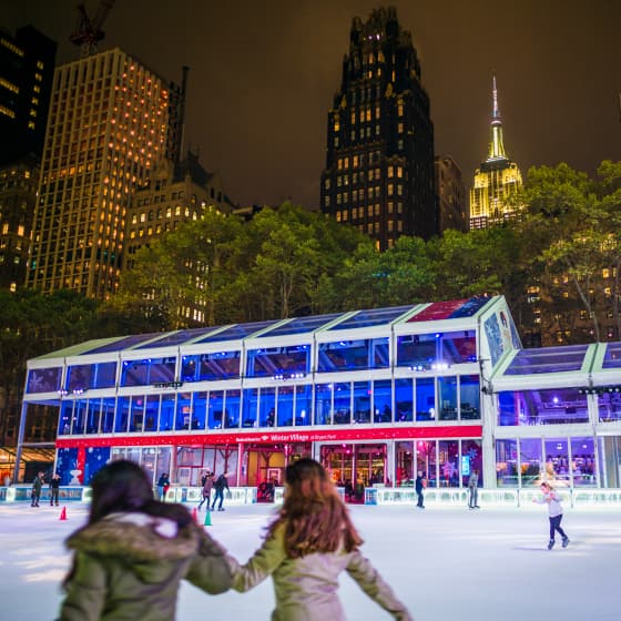 Bryant Park holiday ice skating rink lit up at night