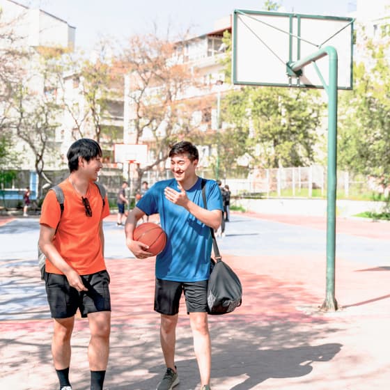 Two people walk off a basketball court after a friendly game