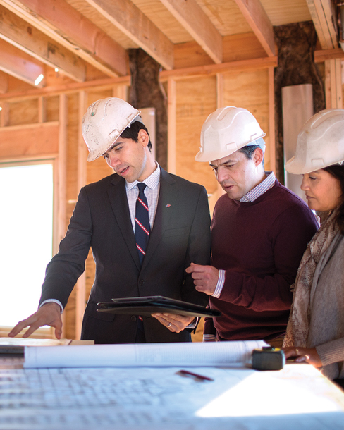 Colleagues in hard hats discussing building plans