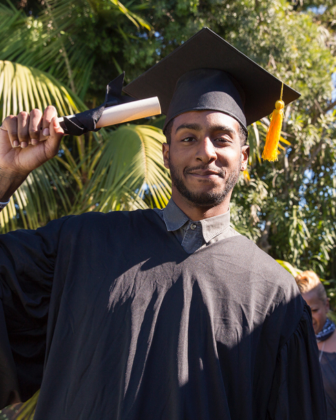 Recent graduate with degree smiling