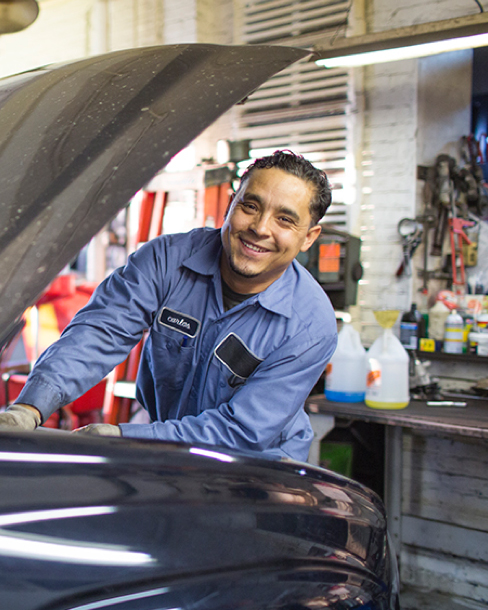 Man smiling working servicing a vehicle