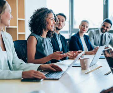 Smiling woman presenting to a group of colleagues in conference room