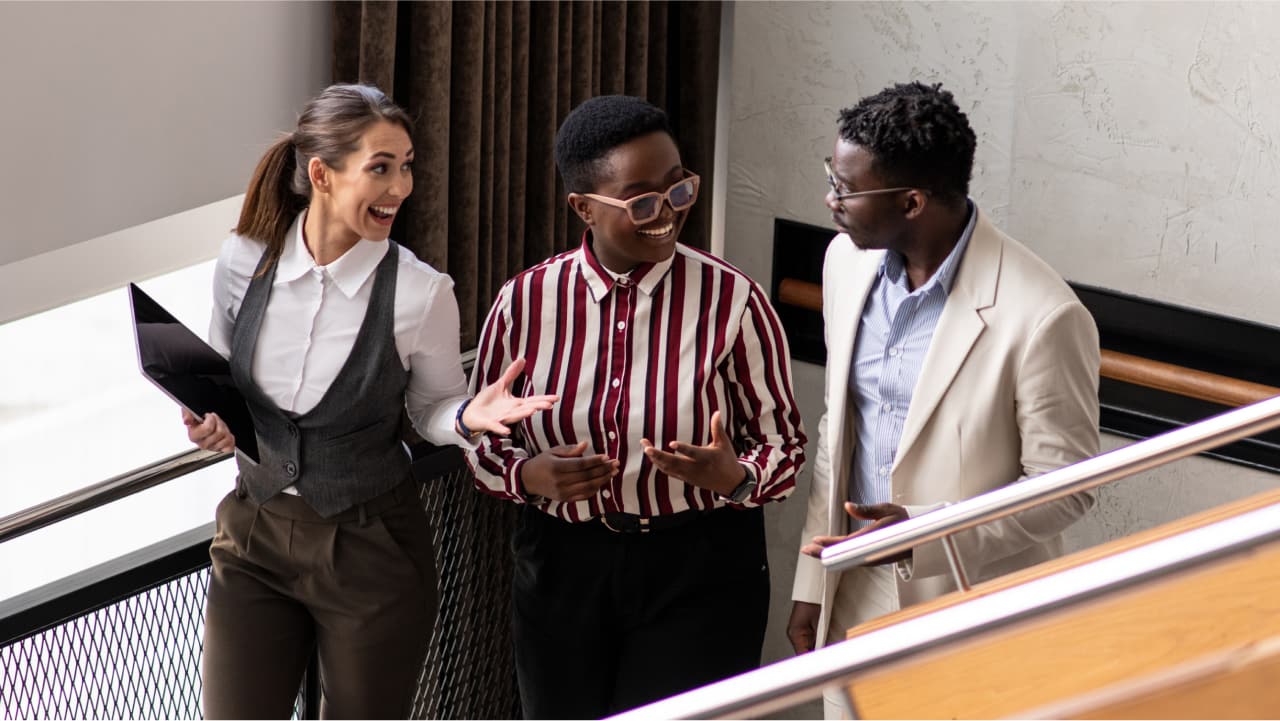 Diverse group of students talk while walking down stairwell