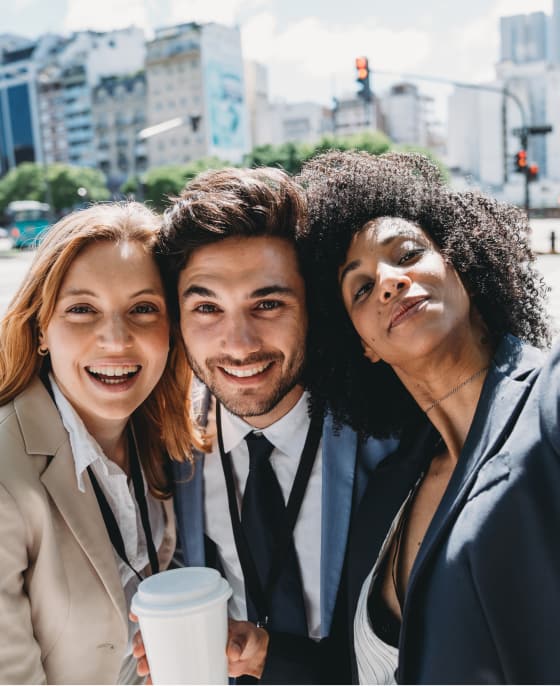 Three colleagues smiling together outside