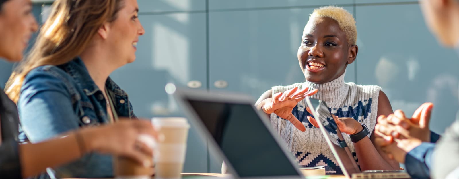 Woman explaining something to her coworkers sitting a table