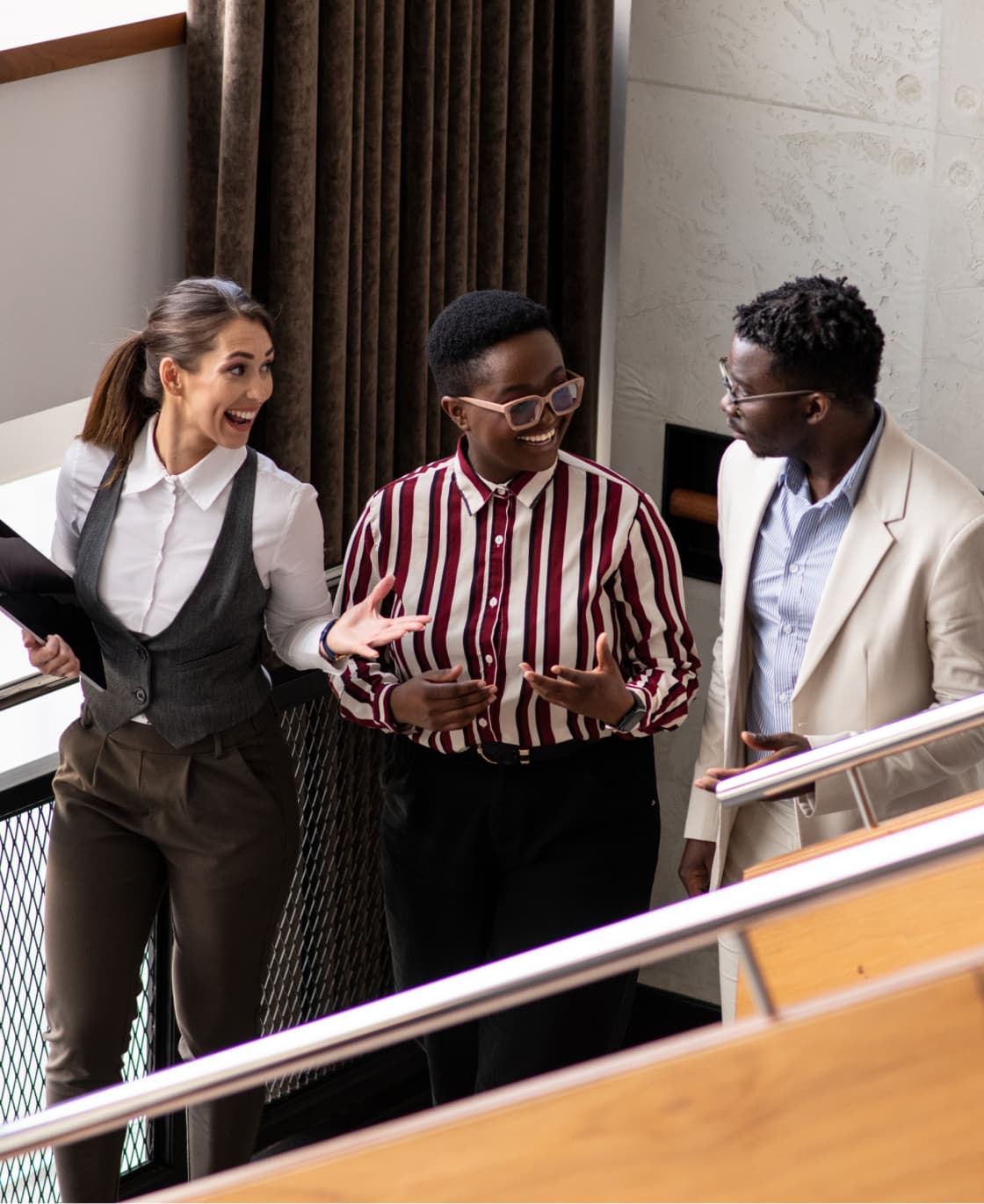 Diverse group of young people walk and talk down a flight of stairs