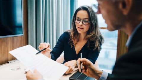 Woman in office setting reviewing paperwork