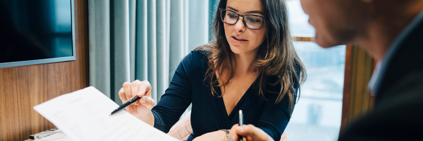 Woman in office setting reviewing paperwork