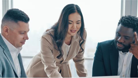 Group in office reviewing material on laptop together