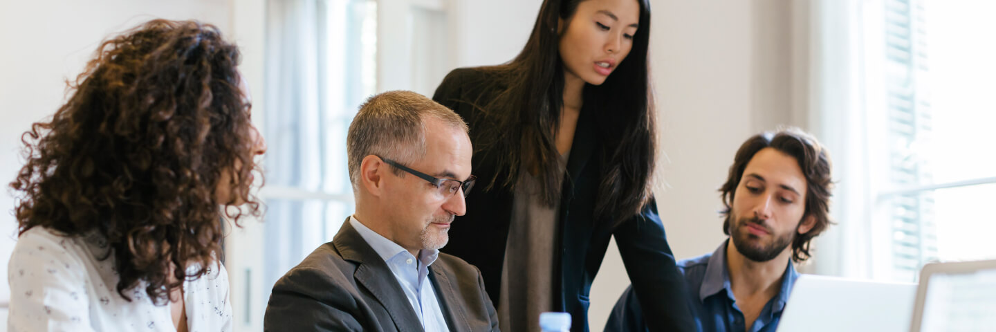 Woman showing team material on laptop screen