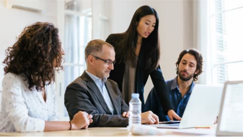 Woman showing team material on laptop screen