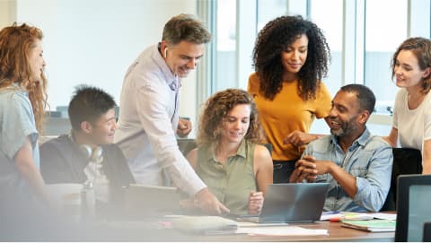 Group of happy colleagues collaborating around a conference table