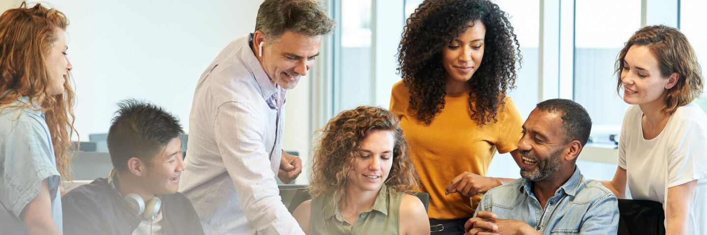 Group of happy colleagues collaborating around a conference table