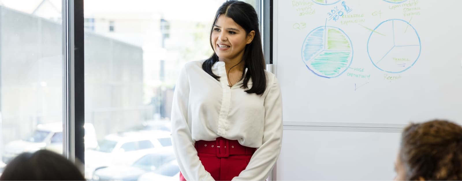 Woman standing in front of whiteboard giving a presentation