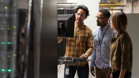 A technician showing employees material in a server room