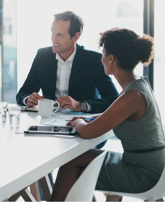 Two colleagues at table with white coffee cup