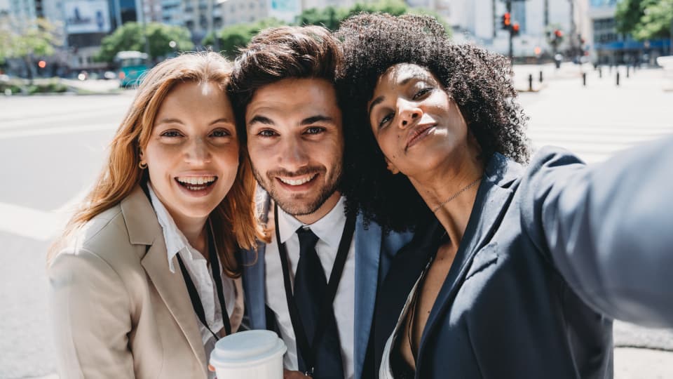  Three colleagues smiling together outside