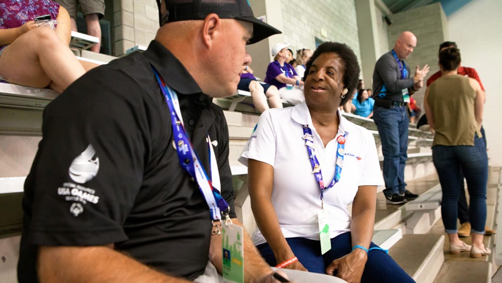 Man and woman talking to each other at Special Olympics event