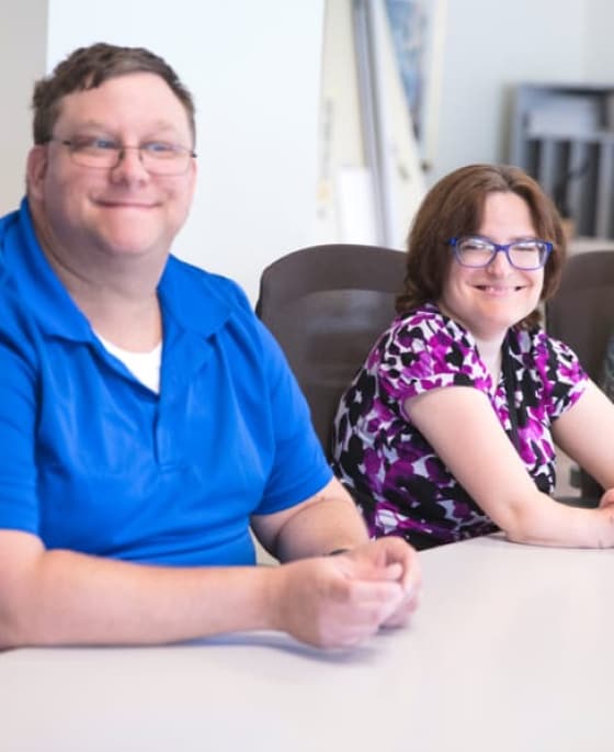 Support Services staff sitting at table and smiling